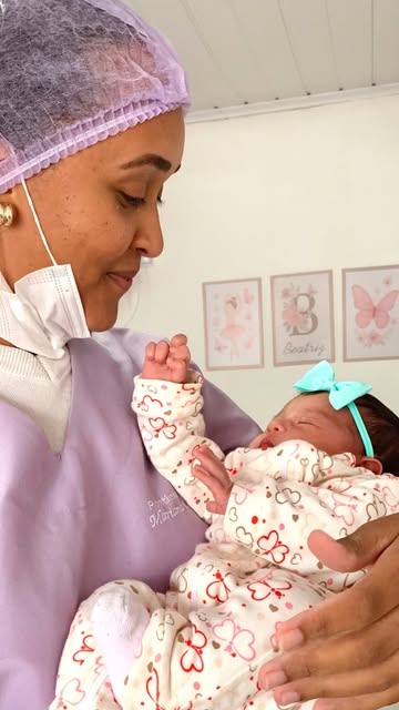 Bebê recém-nascida acolhida no colo pela profissional